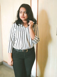 Portrait of woman standing against wall