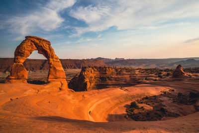 Scenic view of rock formations against cloudy sky