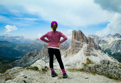 Rear view of woman standing on mountain against sky