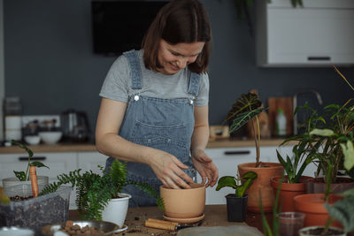 Side view of woman holding potted plant