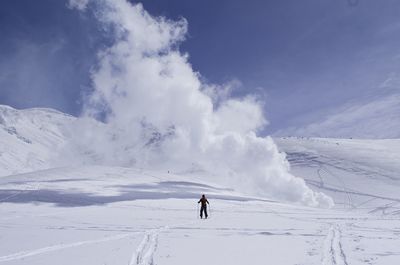 Rear view of person skiing on snowcapped mountain against sky