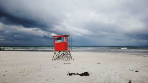 Lifeguard hut on beach against sky