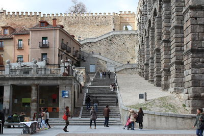 People walking on street against buildings in city