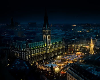 Illuminated cityscape against sky at night