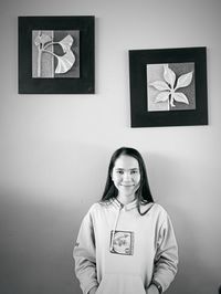 Portrait of a simple woman standing against wall