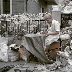 Tailor working against house