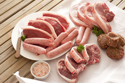 High angle view of various meat on wooden table