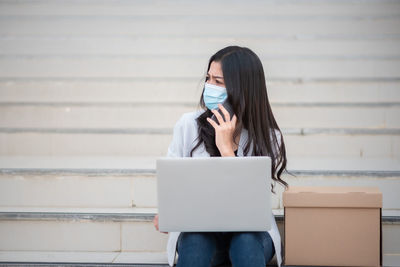 Businesswoman wearing mask while looking away outdoors