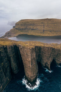 Scenic view of rock formation in sea against sky