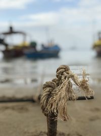 Close-up of rope tied on beach