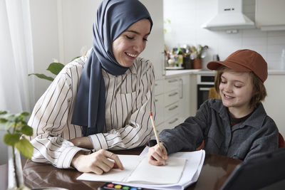 Mother helping son with homework at home