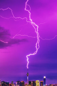 Low angle view of cityscape against sky during blue hour with lightning strike 