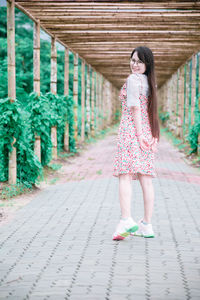 Full length of woman standing on footpath