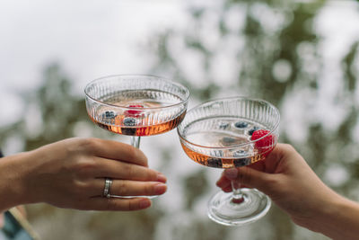 Cropped image of woman holding glass of drink