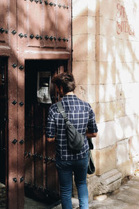 Rear view of man standing against wall