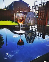 Low angle view of beer glass on table against blue sky