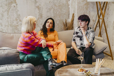 Businesswoman discussing with colleagues sitting on couch during event at convention center