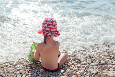 Baby girl holding pebbles on beach