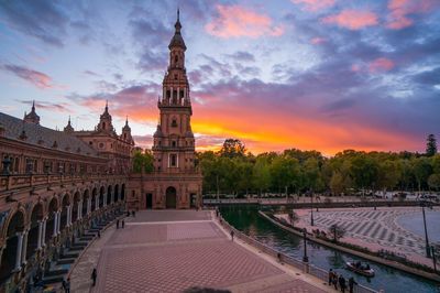 Low angle view of plaza de espana against cloudy sky during sunset