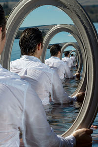 Multiple image of man with mirror in sea