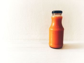 Close-up of glass bottle on table against white background