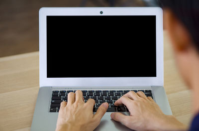 Low section of person using laptop on table