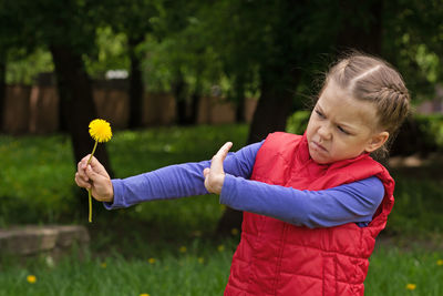 Portrait of boy holding yellow flower