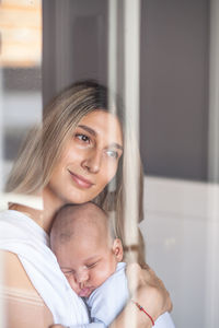 Smiling woman holding son at home