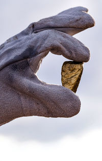 Close-up of hand holding umbrella against sky