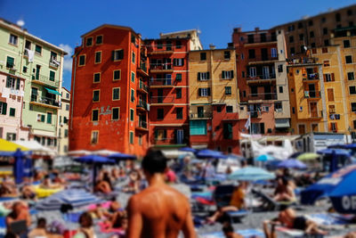 People at beach against buildings in camogli