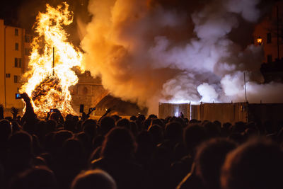 People standing against burning fire