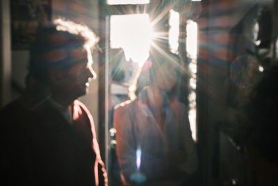 Rear view of man looking at illuminated glass