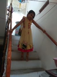 Full length of woman standing on staircase