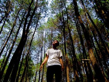 Low angle view of man standing in forest