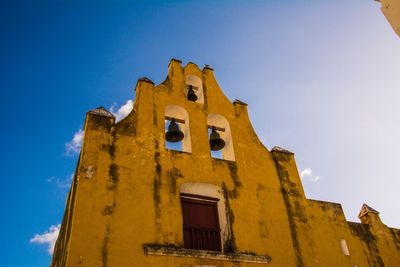 Low angle view of old bell tower against blue sky