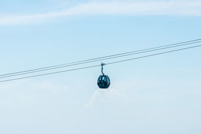 Low angle view of overhead cable car against sky