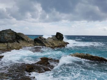 Rocks in sea against sky