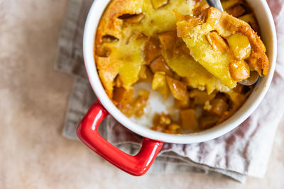 Dutch baby pancake with apples served with honey in ceramic baking dish. delicious sweet breakfast.