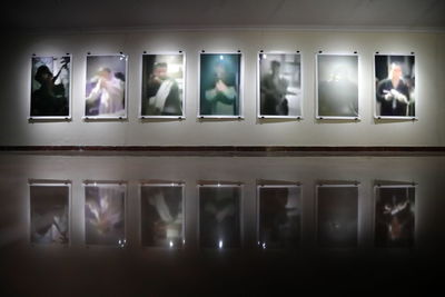 Reflection of illuminated lights on glass window at museum