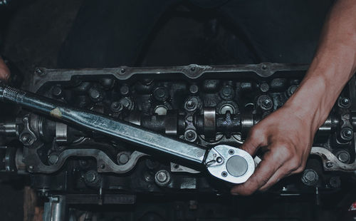 The mechanic is checking the engine.