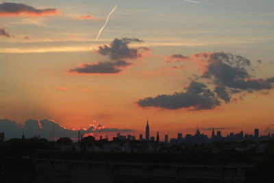 View of city against cloudy sky during sunset