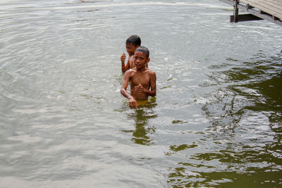 Full length of shirtless boy in water