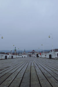 Pier over sea against sky in city