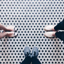 Low section of people standing on tiled floor