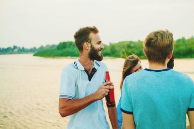 Friends standing on land against sky