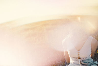 Rear view of woman sitting on floor