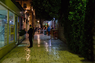 People walking on footpath in city