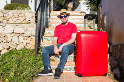 Full length of man sitting in sunglasses