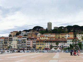 Buildings in city against cloudy sky