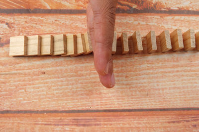 Cropped hand amidst wooden blocks at table
